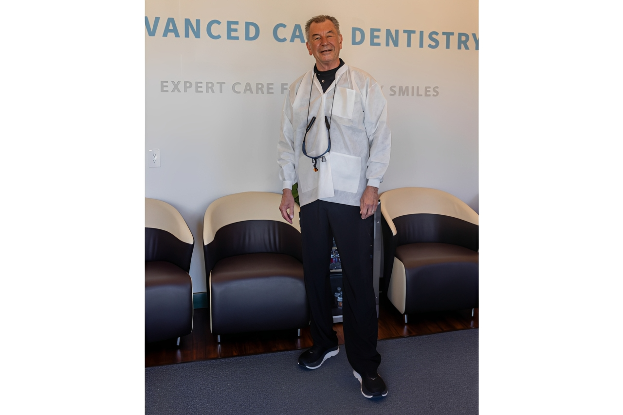 A man stands confidently in a dental clinic reception area.